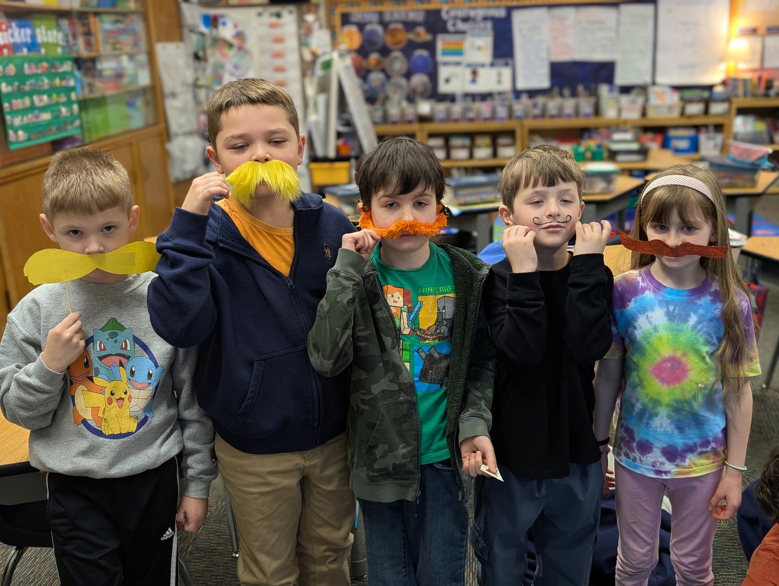 Kindergarten and elementary students laughing together during a fun classroom activity